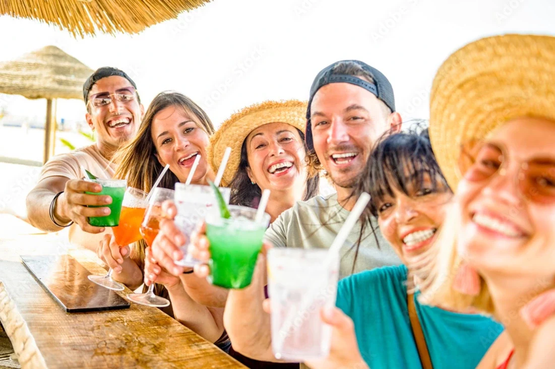 Group of friends enjoying drinks and cocktails in one of the best beach bars in Antigua and Barbuda